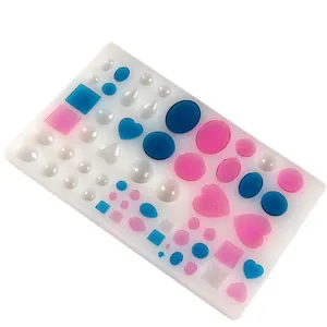 Close-up of a multi-shape silicone mold showing heart and oval cavities filled with resin