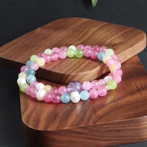 Detailweergave van een kleurrijke dubbelstrengs edelsteen armband met parels op hout