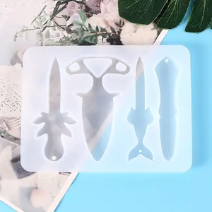 Close-up view of a translucent silicone mold with various dagger and defensive tool shapes