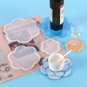Detail of flower-shaped silicone molds for DIY resin coasters on a newspaper