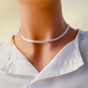 Vue détaillée d'un collier chaîne serpent plate argentée porté par un mannequin