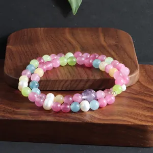 Gedetailleerde weergave van een dubbele kristallen armband met toermalijn en parels op hout