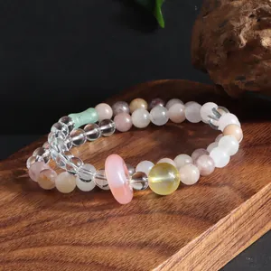 Close-up of multi-gemstone beaded bracelet with a translucent pink spacer ring