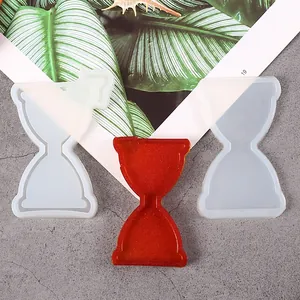 Detailed view of hourglass shaped silicone molds with a finished red resin cast piece