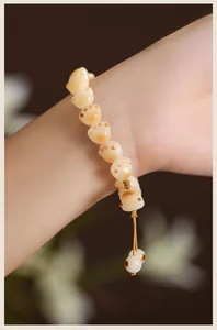 Detailed macro view of cat paw carved Bodhi seed bracelet on a wrist in soft light