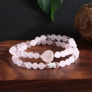 Vue détaillée d'un bracelet en quartz rose à deux rangs avec pierre de cœur et papillon.