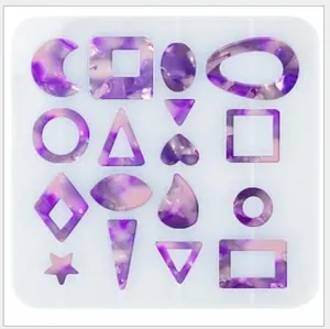 Dettaglio dello stampo in silicone con vari orecchini geometrici in resina viola