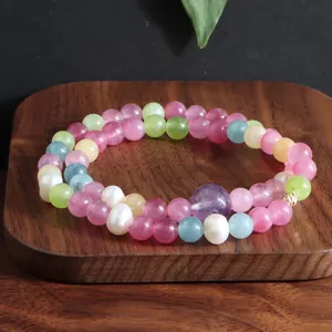 Detail van een dubbellaagse armband met kleurrijke edelsteenkralen en zoetwaterparels