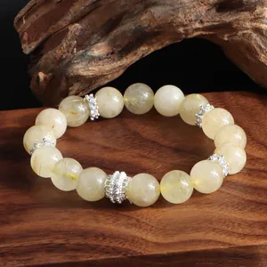 Primer plano de pulsera de cuarzo rutilado dorado con espaciadores de plata