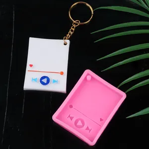 Stampo in silicone e portachiavi lettore musicale finito con dettagli in resina su tavolo