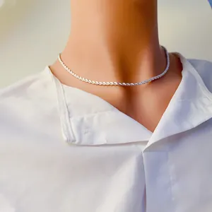 Élégant collier chaîne torsadée en argent pour femme sur un col de chemise blanc