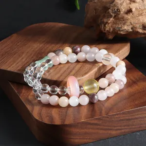 Close-up of double-strand gemstone bracelet featuring pink donut bead and clear quartz