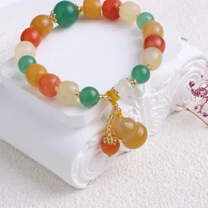 Nahaufnahme eines Naturjade-Perlenarmband im Ethno-Stil mit gelbem Gourd-Anhänger