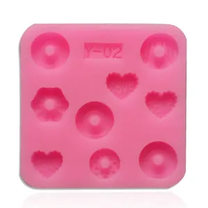 Detailed macro view showing heart and donut shapes of this pink liquid silicone baking mold