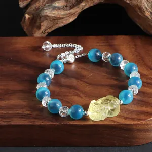 Detailansicht eines blauen Achat-Armbands im chinesischen Stil mit gelbem Anhänger.