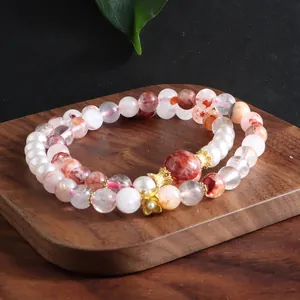 Close-up of multi-layer natural red phantom quartz and pearl beaded bracelet
