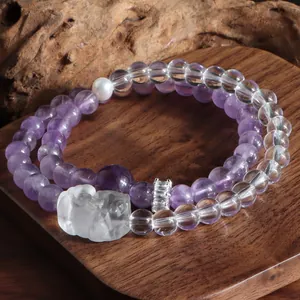 Gros plan détaillé d'un bracelet double en améthyste et cristal blanc avec lion sculpté.