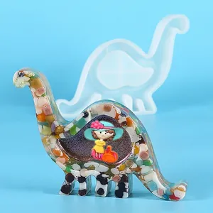 Detail van een dinosaurus siliconen mal en een afgewerkt harsstuk met steentjes