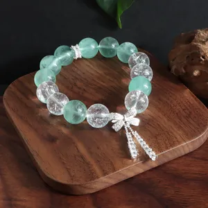 Detailansicht der grünen Fluoritperlen und des silbernen Schleifenanhängers am Armband.