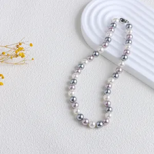 Vue détaillée d'un collier de perles rétro aux couleurs bonbons : blanc, gris et mauve
