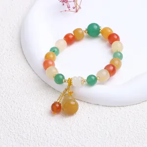 Detailansicht eines bunten Jade-Perlenarmbands mit einem eleganten gelben Flaschenkürbis-Anhänger