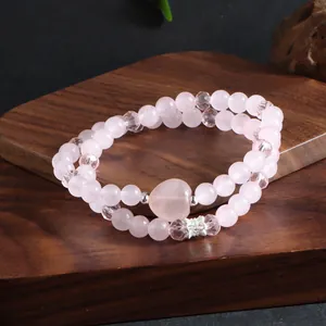 Détail d'un bracelet double couche en quartz rose naturel avec perles de cristal et cœur.