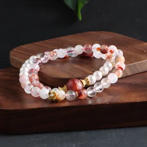 Detailed view of a double-strand natural red phantom quartz and pearl beaded bracelet