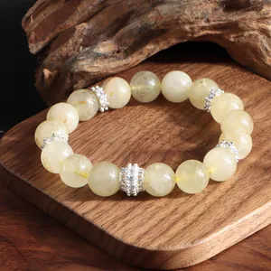Detalle de una pulsera de cuarzo rutilado dorado con espaciadores de plata y circonitas