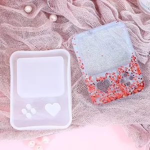 Macro view of retro handheld console shaped silicone mold and finished glitter resin piece