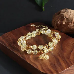 Macro view of a beautiful natural citrine double-strand bracelet with golden tassels