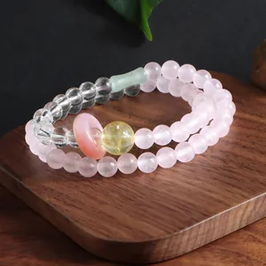 Macro view of double-strand pink quartz and crystal beaded bracelet on a wooden stand