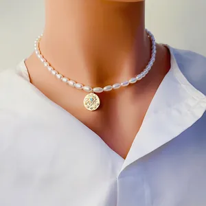 Gros plan d'un collier de perles élégant avec pendentif œil doré sur chemise blanche