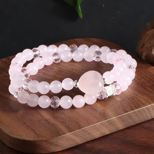 Gros plan d'un bracelet en quartz rose à deux rangs avec perle cœur et breloque couronne