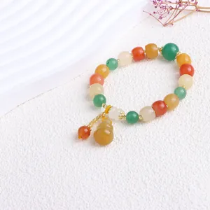 Detailansicht eines bunten Naturjade-Perlenarmbands mit gelbem Flaschenkürbis-Anhänger