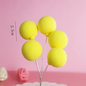 Macro detail of yellow clay balloon cake toppers showing 2.5cm diameter measurement