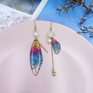 Detail der asymmetrischen Regenbogen Zikadenflügel Ohrringe mit Perlen und Goldherz Quaste.