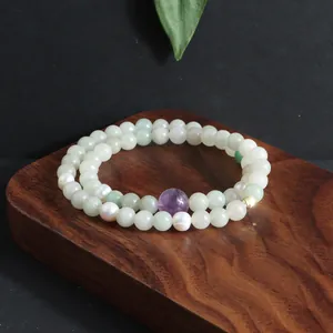 Detailopname van een dubbele streng edelsteen armband met parels en kristallen.