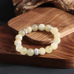 Vista detallada de pulsera de cuarzo rutilado dorado con espaciadores de plata decorados