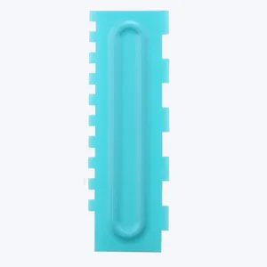 Close-up of light blue plastic cake comb scraper with dual serrated pattern edges