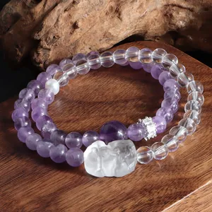 Gros plan d'un bracelet double couche en améthyste et cristal de roche avec lion sculpté
