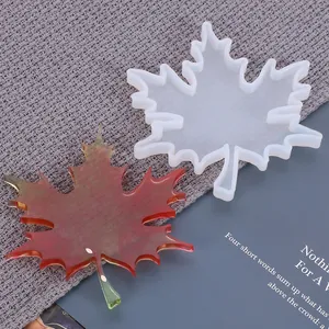 Detailed macro shot of a maple leaf silicone mold with finished red resin coaster