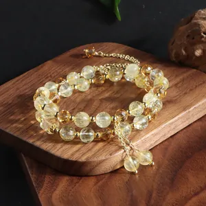 Detail shot of a natural citrine double-strand bracelet with elegant gold tassel