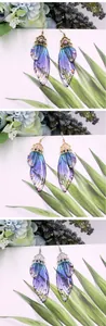 Ohrringe mit Schmetterlingsflügeln in Blau-Violett-Verlauf und Kristallen, Gold und Silber.