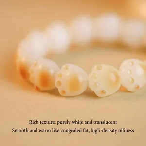 Close-up of handmade cat paw white jade bodhi root bead bracelet with charred finish.