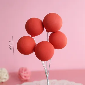 Detailed view of five red clay balloon cake toppers on wires with 2.5cm size annotation