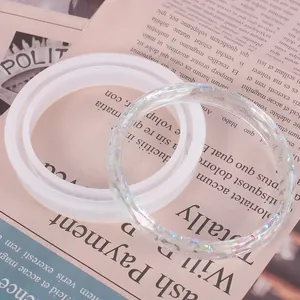 Nahaufnahme einer Silikonform für Armbänder und eines fertigen Harzarmbandes mit Glitzer