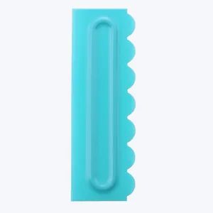 Detail view of turquoise plastic cake scraper comb with scalloped edge for baking.