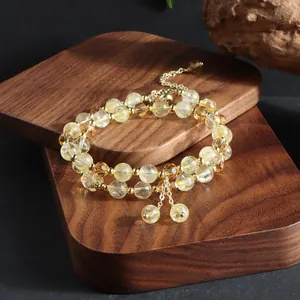 Detailed macro view of natural citrine double-layer beaded bracelet with gold tassels