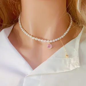 Vue détaillée d'un collier de perles avec un pendentif en zircon rose en goutte