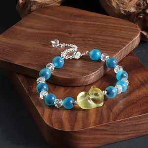 Nahaufnahme eines Armbands aus blauen Achaten und Kristallen mit Katzenanhänger